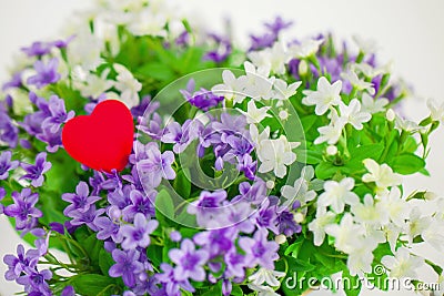 Heart, symbol of love in a bouquet small flowers. Stock Photo