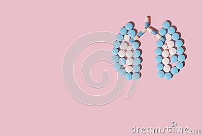 Heart of white and blue tablets on a pink background. The concept of a cure for the the human lungs Stock Photo