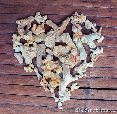 Heart from white corals on wooden background. Seashore love decor from beach finding. Stock Photo