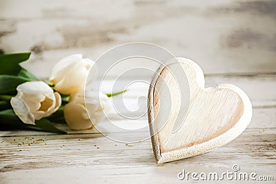 Heart of wood and tulips on a white painted wooden background, r Stock Photo