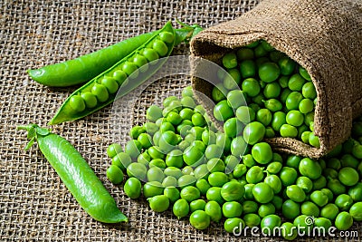 Hearthy fresh green peas and pods on rustic fabric Stock Photo