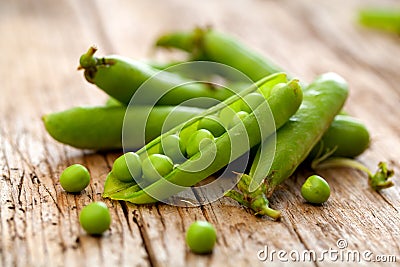 Hearthy fresh green peas and pods on rustic wooden background. Stock Photo