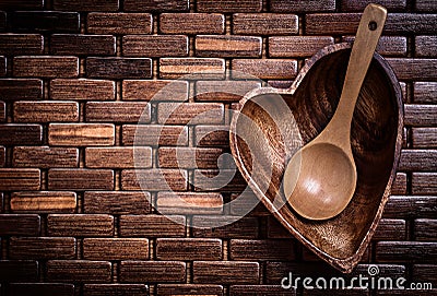 Heartshaped wood teabowl and spoon on wooden mat horizontal view Stock Photo
