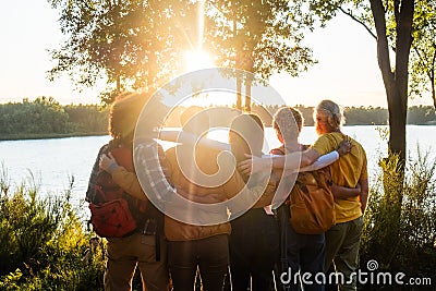 Sunset Comradeship: Friends United by Lakeside Views Stock Photo
