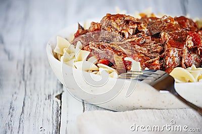 Hearty bowl of beef ragu over pasta Stock Photo