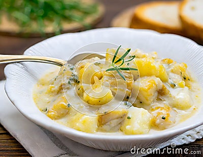 hearty bowl of Cullen Skink, a traditional Scottish soup, served with grilled bread on a rustic wooden table, suggesting a Stock Photo