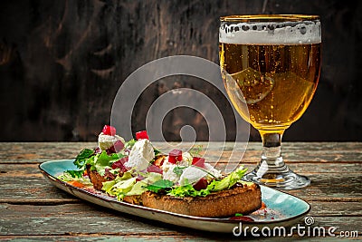 Hearty snack with different kinds of spreads on farmhouse bread served with a fresh yeast wheat beer on an old wooden table Stock Photo