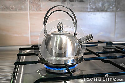 Heat metal kettle tea on gas, boiling water, top stove stainless Stock Photo