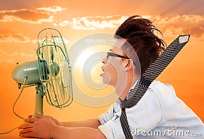 The heat wave is coming,business man holding a electric fan Stock Photo