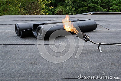 Heating and melting bitumen roofing felt Flat roof installation Stock Photo