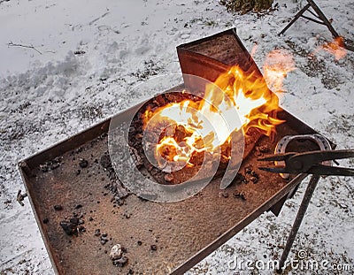 Heating process of metal bar on hot coals Stock Photo