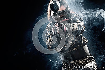 Heavily armed masked paintball soldier isolated on black background. Ad concept. Stock Photo