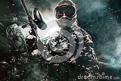 Heavily armed masked paintball soldier on post apocalyptic background. Ad concept. Stock Photo