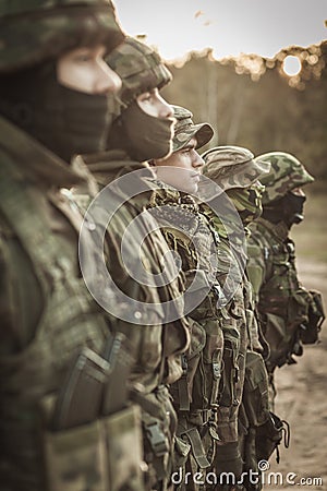 Heavily armed soldiers in a row Stock Photo