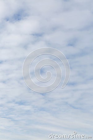 A heavily cloudy bright blue sky. Space for text. Background. Vertical Stock Photo