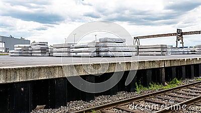 Heavy aluminum bars lying on each other on stack in the square of an aluminum smelter. Stock Photo