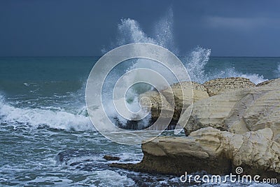 Heavy clouds with stormy waves beating against rocks and cliffs Stock Photo