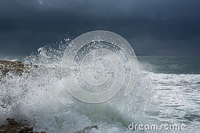 Heavy clouds with stormy waves beating against rocks and cliffs Stock Photo