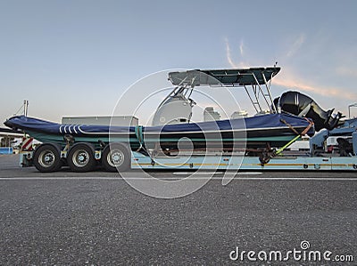 Heavy-duty truck carrying outboard rigid Inflatable boat Stock Photo