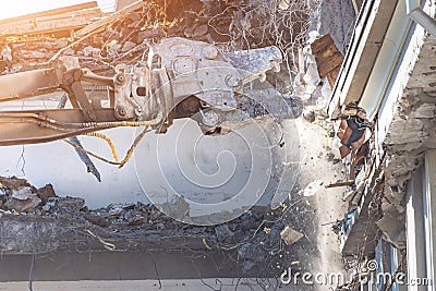 Heavy equipment hydraulic shears arrow dismantle the building, demolition destruction. Close up view Stock Photo