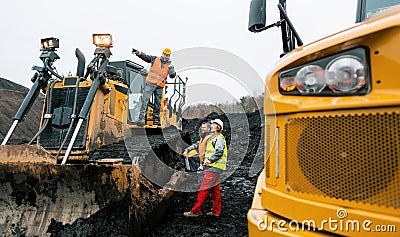 Heavy machinery and workers in pit of quarry Stock Photo