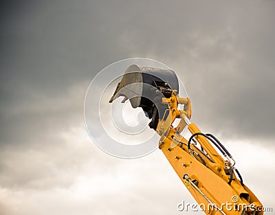 Heavy orange excavator arm reaches the sky Stock Photo