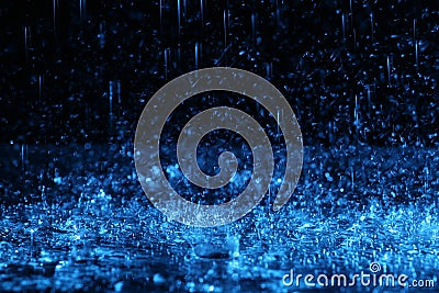 Heavy rain falling down on ground against dark background, toned Stock Photo