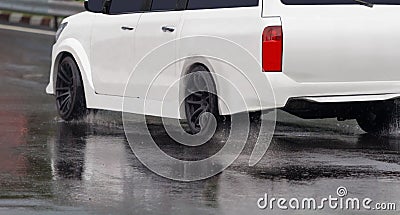 Heavy rain and puddles on the road cause skidding or sliding of a cars tires across a wet surface Stock Photo