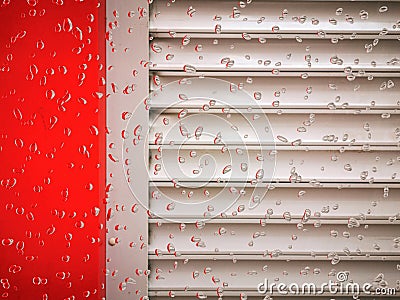 heavy rain on a red walled industrial building with grey shutters Stock Photo