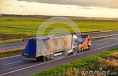 Heavy Recovery Truck Tows a Semitrailer truck on highway. Emergency Rescue Wrecker Tow Truck coach haul car along road. Towing Stock Photo