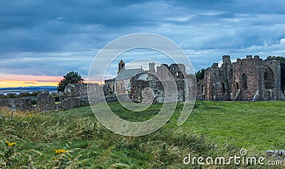 Heavy sky at Sunset over Lindisfarne Priory, Holy Island. Stock Photo