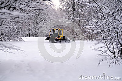 14.12.2021. Heavy snowfall in Moscow. Snowcat ratrak rides up the hill and preparation ski slope Editorial Stock Photo