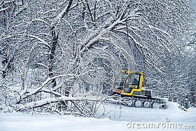 14.12.2021. Heavy snowfall in Moscow. Snowcat ratrak rides up the hill and preparation ski slope Editorial Stock Photo