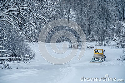 14.12.2021. Heavy snowfall in Moscow. Snowcat ratrak rides up the hill and preparation ski slope Editorial Stock Photo