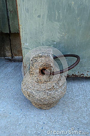 A Heavy Stone Door Stop Holds Open a Door Stock Photo