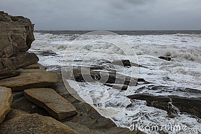 Rough sea and heavy waves on the rocky coast, Seaton Sluice. Stock Photo