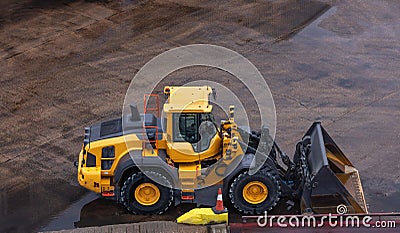 Heavy yellow bulldozer parked on a concrete site Stock Photo