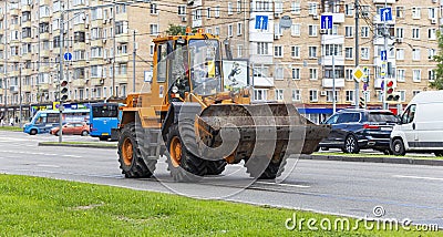 A heavy yellow road excavator on the road in the city. Moscow, Russia Editorial Stock Photo