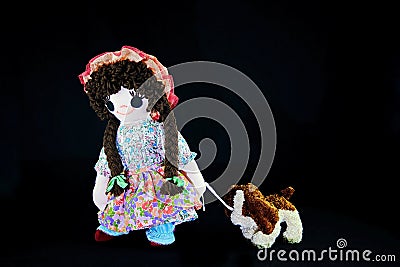 Heel Puppy 2, let`s go for a walk. New pose. Vintage girl rag doll with her puppy; presented on a plain black background. Stock Photo