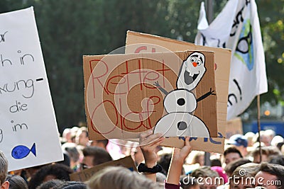 Protest sign with snowman saying `Safe Olaf` held up by young people during Global Climate Strike / Fridays for future Editorial Stock Photo