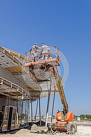 Height workers with help of cherry picker are working on new met Editorial Stock Photo
