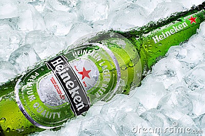 Frosty Heineken beer bottle laying on ice cubes Editorial Stock Photo