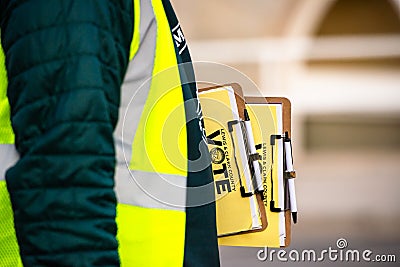 Helena, Montana / November 3, 2020: Election official holding vote ballots waiting for voters outside polling station, Lewis and Editorial Stock Photo