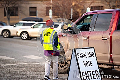 Helena, Montana / November 3, 2020: Woman poll worker helping voter at polling station, park vote in truck, presidential Election Editorial Stock Photo