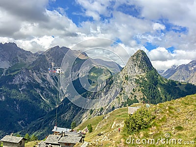 Helicopter conveying construction material in the Alps near Courmayeur Italy Stock Photo