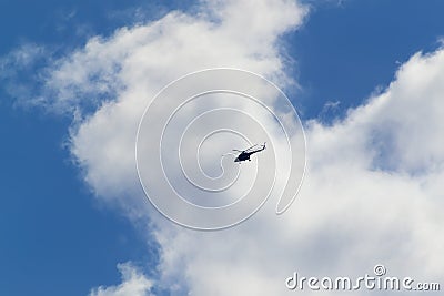 A helicopter flies high in the sky Stock Photo