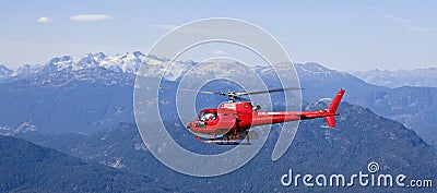 Helicopter flying above mountains Stock Photo