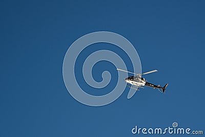 Helicopter flying high in the blue sky Stock Photo