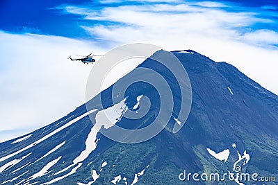 Helicopter flying over Ilyinsky Volcano and Kurile lake Stock Photo