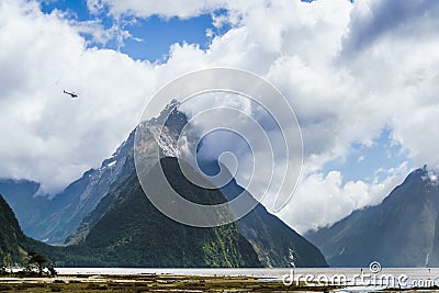 Helicopter flying past the giant Mitre Peak mountain of the Milf Stock Photo